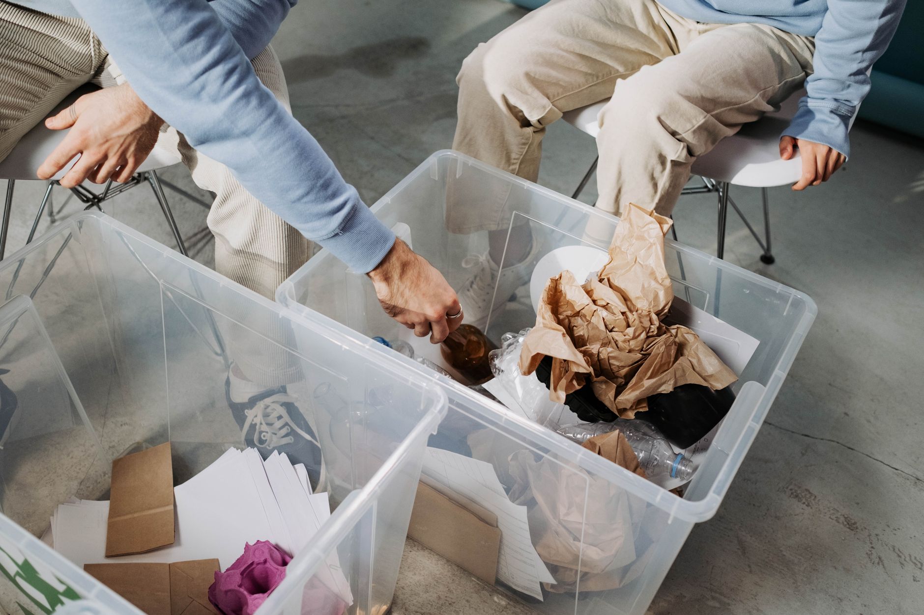 People sorting household objects into storage boxes